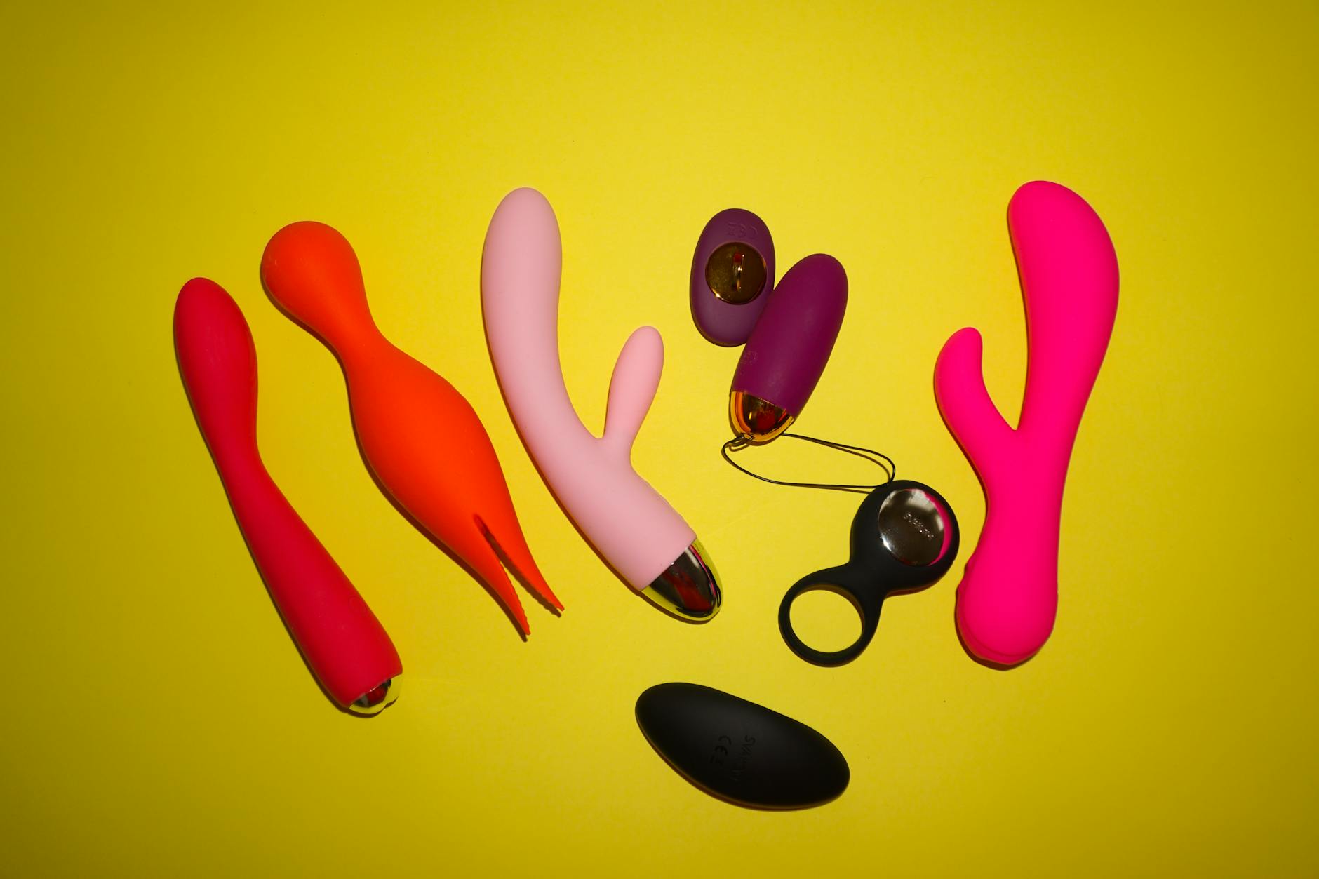 Mulher segurando um vibrador pessoal azul em frente a um fundo roxo sólido