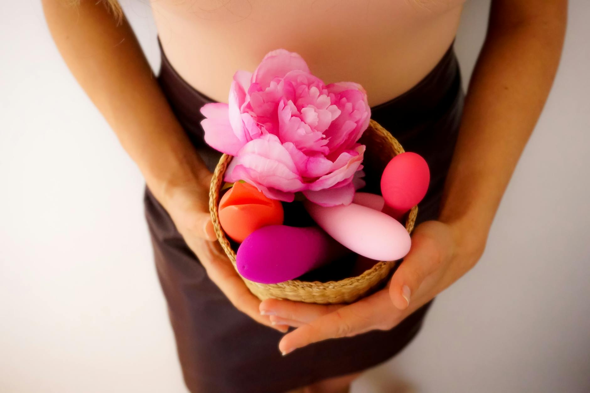 Mulher segurando um vibrador rosa, mostrando autoconhecimento e bem-estar corporal